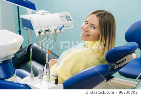 The girl smiles at the dentist and looks at her The girl smiles at the dentist and looks at her 96230702
