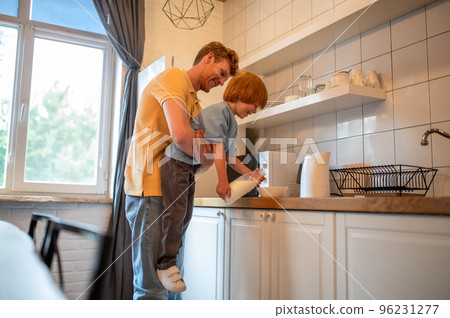 Dad and son preparing breakfast in the kitchen Dad and son preparing breakfast in the kitchen 96231277