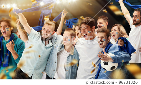 Young emotive football fans from Argentina cheering national soccer team with blue scarfs at crowded stadium. Concept of sport, support, team event, competition Young emotive football fans from Argentina cheering national soccer team with blue scarfs at crowded stadium. Concept of sport, support, team event, competition 96231320