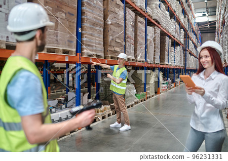 Storehouse workers working supervised by an inspector 96231331