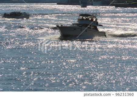 A boat running on the shining river 96231360