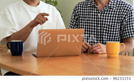 Sexual minority male couple using a computer at home Faceless Sexual minority male couple using a computer at home Faceless 96233153