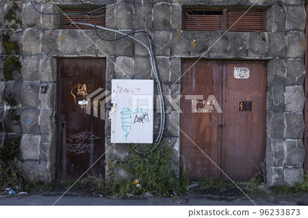 The metal doors of the entrance to the transformer in the wall of red brick 96233873