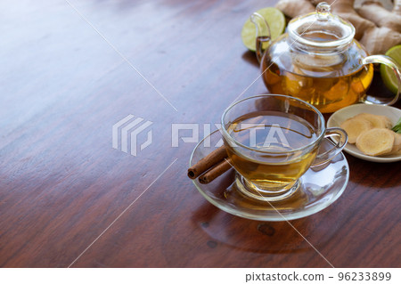 a cup of tea with ginger root, lime, cinnamon and teapot on white background. Health drink concept. 96233899