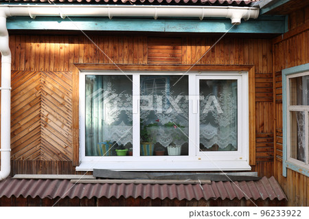 Window in an old wooden house view from the street 96233922