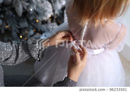 New Year, mom dresses her daughter. 2022 New Year, mom dresses her daughter. 2022 96233981