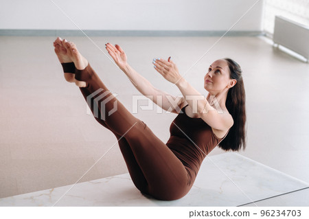 Pregnant girl. A woman does yoga on a hammock in the gym. The concept of a healthy lifestyle, Motherhood Pregnant girl. A woman does yoga on a hammock in the gym. The concept of a healthy lifestyle, Motherhood 96234703