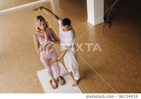 a man and a woman do yoga on boards with nails in the gym a man and a woman do yoga on boards with nails in the gym 96234838