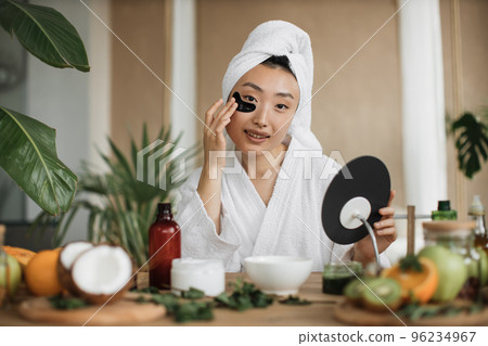 Pretty asian woman sitting at table with fruits, vegetables for homemade cosmetics Pretty asian woman sitting at table with fruits, vegetables for homemade cosmetics 96234967
