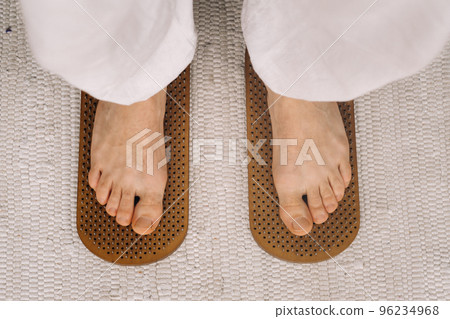 The man's feet are next to boards with nails. Yoga classes The man's feet are next to boards with nails. Yoga classes 96234968
