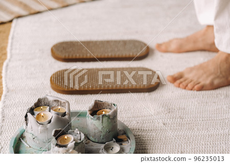 The man's feet are next to boards with nails. Yoga classes The man's feet are next to boards with nails. Yoga classes 96235013