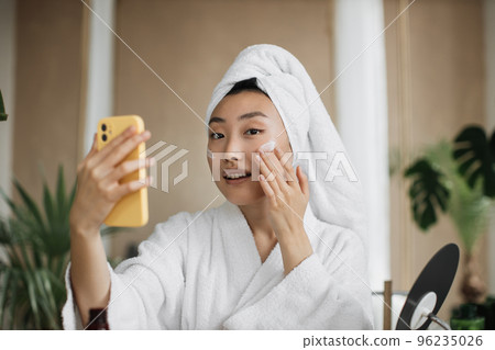 Close up portrait of happy asian woman holding bowl applying white mask homemade moisturizing 96235026