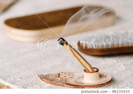 A smoking Palo Santo stick and boards with nails for yoga classes A smoking Palo Santo stick and boards with nails for yoga classes 96235033