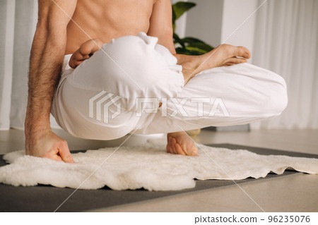 a man with a bare torso does yoga in a fitness room. the concept of a healthy lifestyle 96235076