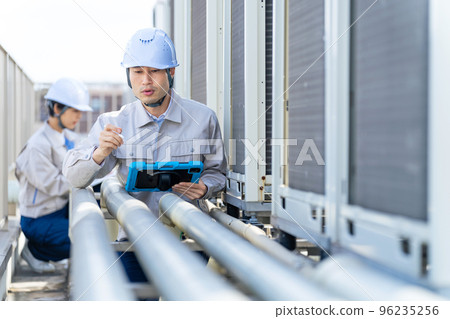 Engineer inspecting piping Engineer inspecting piping 96235256