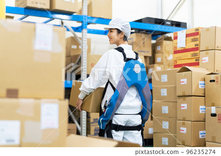一名身穿動力輔助服並在食品倉庫提行李的婦女 96235274