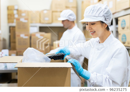 一個女人用盒子包裝食物學校午餐中心送貨上門食品包裝廠 96235275