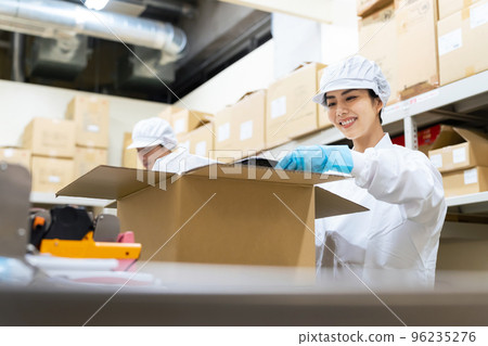 A woman packing food in a box School lunch center Home delivery food packaging factory A woman packing food in a box School lunch center Home delivery food packaging factory 96235276
