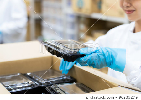 一個女人用盒子包裝食物學校午餐中心送貨上門食品包裝廠 一個女人用盒子包裝食物學校午餐中心送貨上門食品包裝廠 96235279
