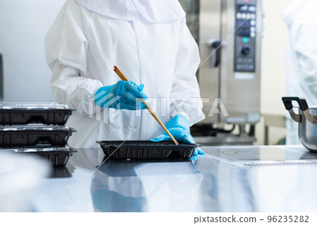 烹飪人員將食物裝入便當盒 學校午餐中心便當店 96235282