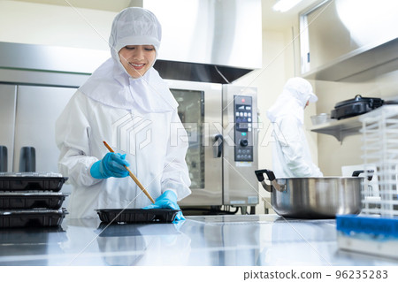 烹飪人員將食物裝入便當盒 學校午餐中心便當店 96235283