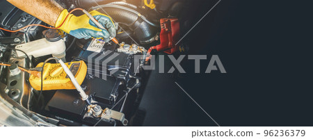 A technician checking DC voltage stable of the car battery with digital multimeter probe 96236379
