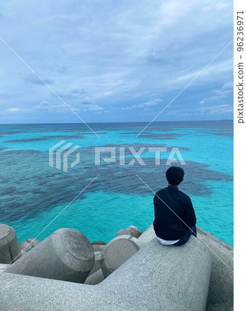 Back view of a young man at dusk in a tetrapod 96236971