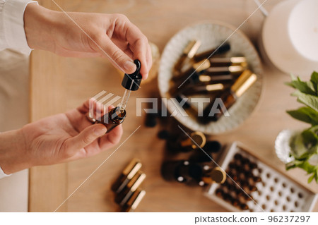 Close-up of female hands holding a bottle of essential oil, Aromatherapy Close-up of female hands holding a bottle of essential oil, Aromatherapy 96237297