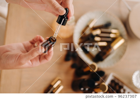 Close-up of female hands holding a bottle of essential oil, Aromatherapy 96237307