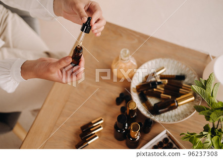 Close-up of female hands holding a bottle of essential oil, Aromatherapy 96237308