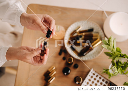 Close-up of female hands holding a bottle of essential oil, Aromatherapy Close-up of female hands holding a bottle of essential oil, Aromatherapy 96237550