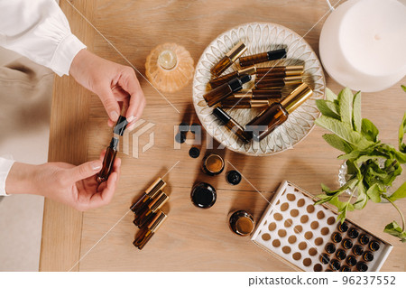 Close-up of female hands holding a bottle of essential oil, Aromatherapy Close-up of female hands holding a bottle of essential oil, Aromatherapy 96237552