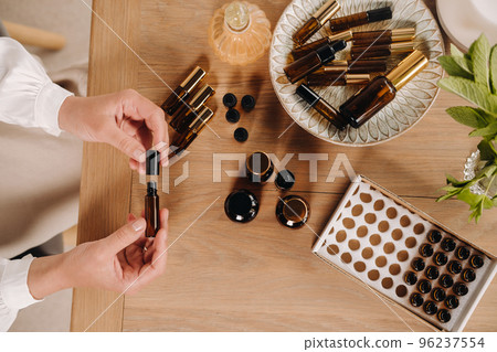 Close-up of female hands holding a bottle of essential oil, Aromatherapy Close-up of female hands holding a bottle of essential oil, Aromatherapy 96237554