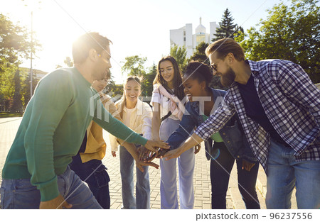 Team of happy young multiethnic friends stack their hands while having fun in the city Team of happy young multiethnic friends stack their hands while having fun in the city 96237556