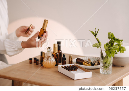 Close-up of female hands holding a bottle of essential oil, Aromatherapy 96237557