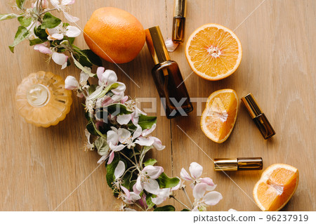 Essential oil in bottles with the aroma of apple and mint flowers lying on a wooden surface 96237919