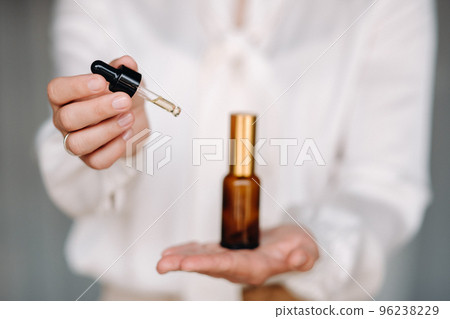 Close-up of female hands holding a bottle of essential oil, Aromatherapy Close-up of female hands holding a bottle of essential oil, Aromatherapy 96238229