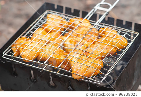 Grilled chicken wings with spices on the grill, cooked on fire, barbecue Grilled chicken wings with spices on the grill, cooked on fire, barbecue 96239023