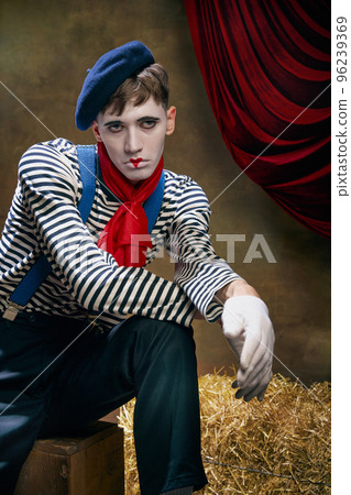 Closeup portrait of male mime artist expressing sadness and loneliness over dark retro circus backstage background. Concept of emotions, art, fashion, style 96239369