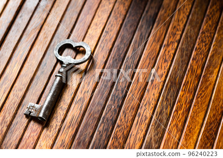the old key lies on an old wooden table, natural textures, the concept of discoveries, secrets, answers 96240223