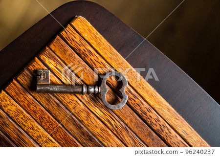 the old key lies on an old wooden table, natural textures, the concept of discoveries, secrets, answers the old key lies on an old wooden table, natural textures, the concept of discoveries, secrets, answers 96240237