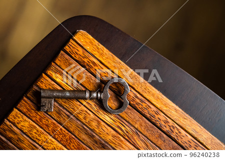 the old key lies on an old wooden table, natural textures, the concept of discoveries, secrets, answers 96240238