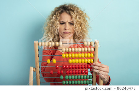 Girl with abacus is confused about the sum . cyan background Girl with abacus is confused about the sum . cyan background 96240475