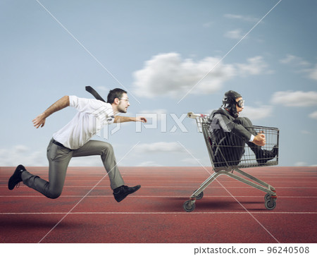 Businessman runs fast driving a cart during a competition 96240508