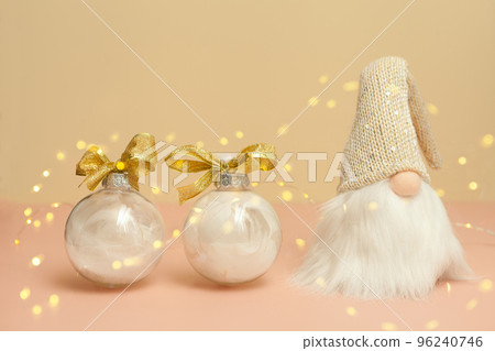 gnome and christmas balls with bokeh on pink - white decorations with feathers. New Year's gifts gnome and christmas balls with bokeh on pink - white decorations with feathers. New Year's gifts 96240746