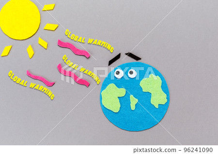 Environment disaster. The planet earth and the sun are carved out of felt. Gray background. Flat lay. The concept of global warming Environment disaster. The planet earth and the sun are carved out of felt. Gray background. Flat lay. The concept of global warming 96241090
