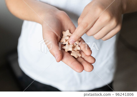 In the hands of a child, a vitamin in the shape of an asterisk 96241806