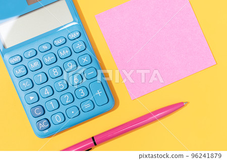 Flat lay of Calculator, pen and blank sticky note on yellow background. Vibrant colors Mock up 96241879