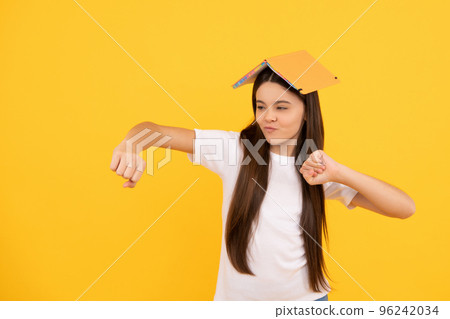 kid dancing with book on yellow background, fun 96242034