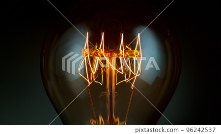 Close-up of shining light bulb, dark background 96242537